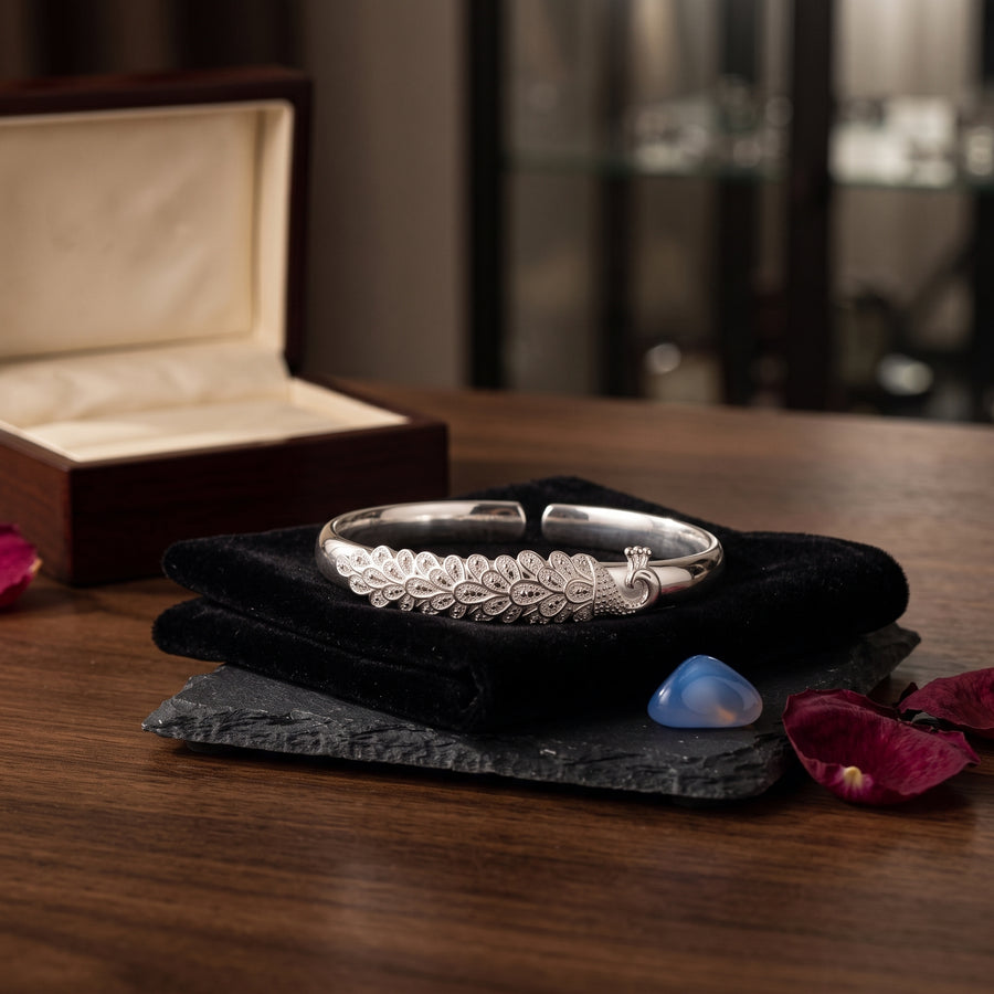 Silver plume cuff bracelet displayed in an elegant jewelry setting